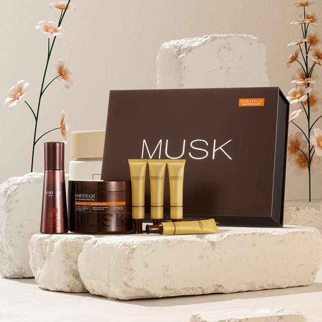 Zestaw kosmetyków do włosów MOHEQI MUSK, umieszczony na białych, kamiennych blokach, na beżowym tle. W skład zestawu wchodzi ciemnobrązowe pudełko z napisem "MUSK", duży słoik z maską do włosów, buteleczka z szamponem oraz trzy mniejsze, złote tubki.