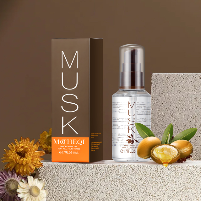 Pudełko i butelka olejku do włosów MOHEQI MUSK o pojemności 50 ml, umieszczone na białych, kamiennych blokach. Olejek przeznaczony jest do każdego rodzaju włosów i zawiera olejek macadamia. W tle znajdują się kwiaty i orzechy macadamia, które symbolizują skład produktu. Całość jest sfotografowana na beżowym tle.
